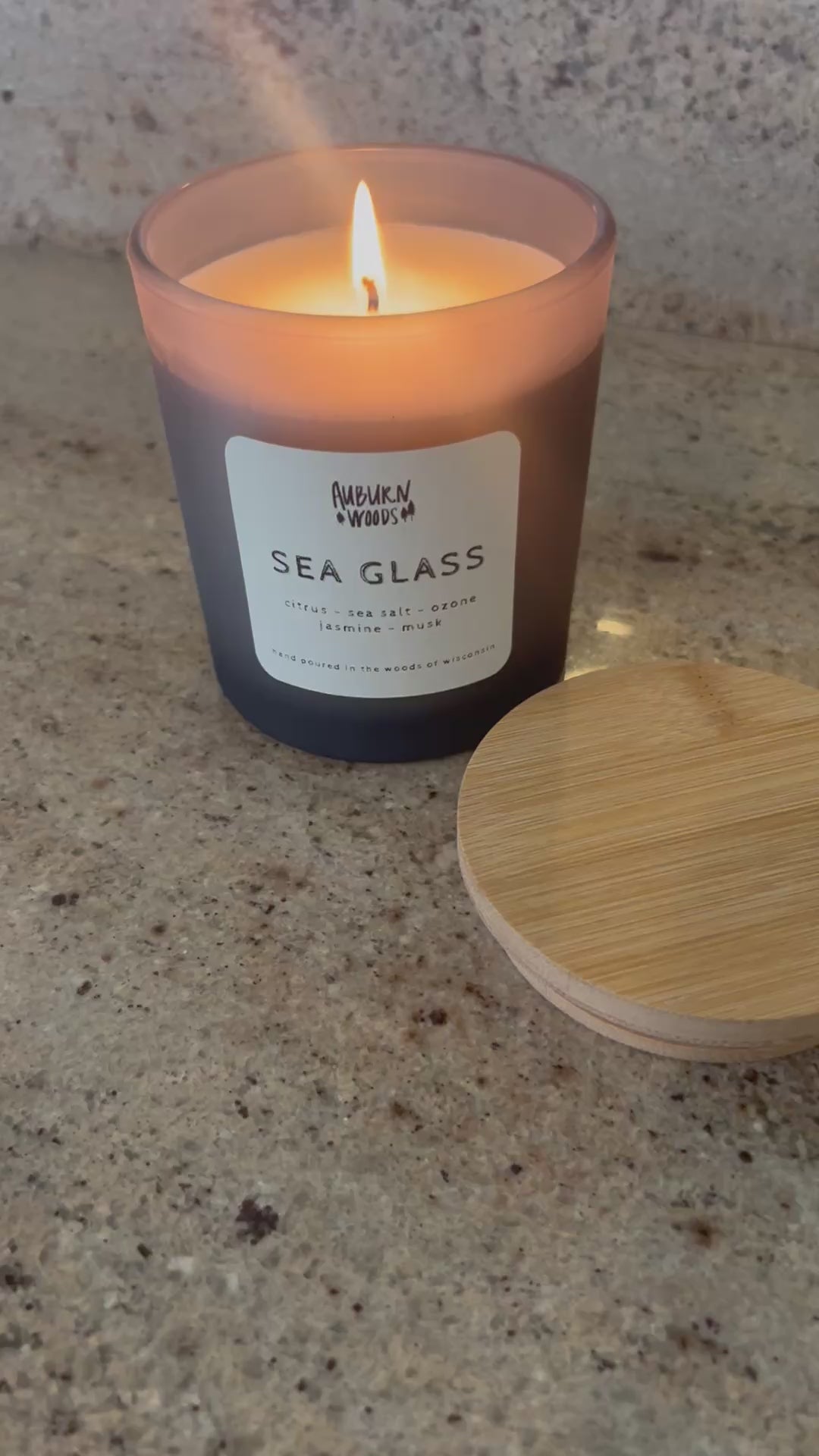 sea glass candle burning. smells like citrus, sea salt, jasmine, ozone. coconut wax, cottoon wick