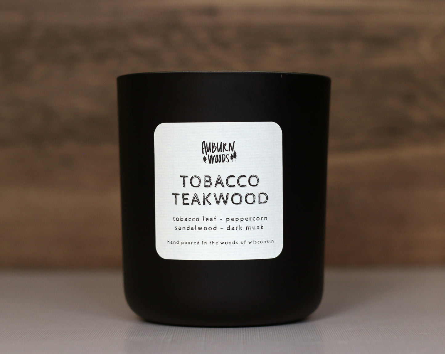 tobacco teakwood wood wick candle in a matte black jar. clean burning coconut wax. notes of tobacco leaf, peppercorn, sandalwood, dark musk, made in wisconsin